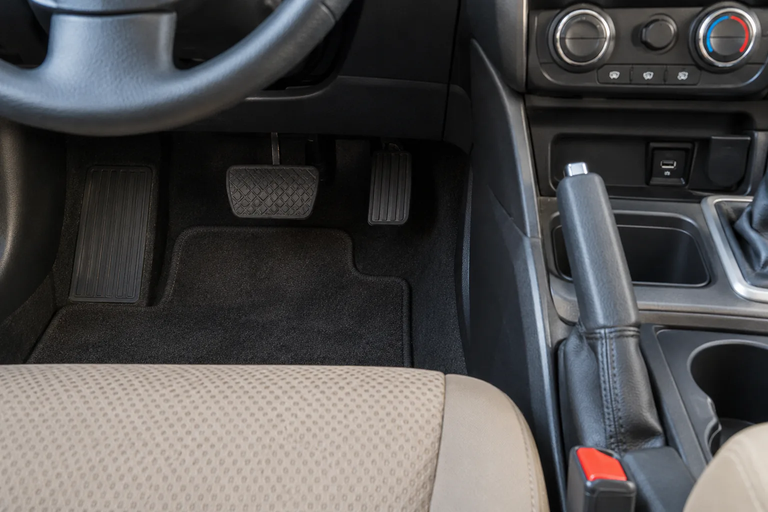 First-person parked-cabin view showing parking-brake control at rest and unobstructed pedal area